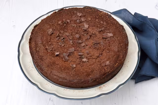Decorated chocolate almond cake on plate.