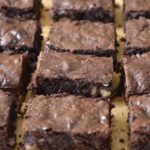 Homemade chocolate fudge brownies on wooden board.