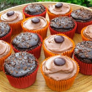 A tray of mixed milk and dark chocolate cupcakes in red and orange cases.