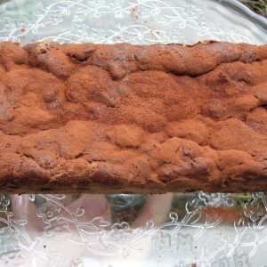 A loaf of chilli chocolate chestnut cake on a glass stand.