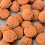 A pile of lemon balm chocolate truffles coated in cocoa powder.