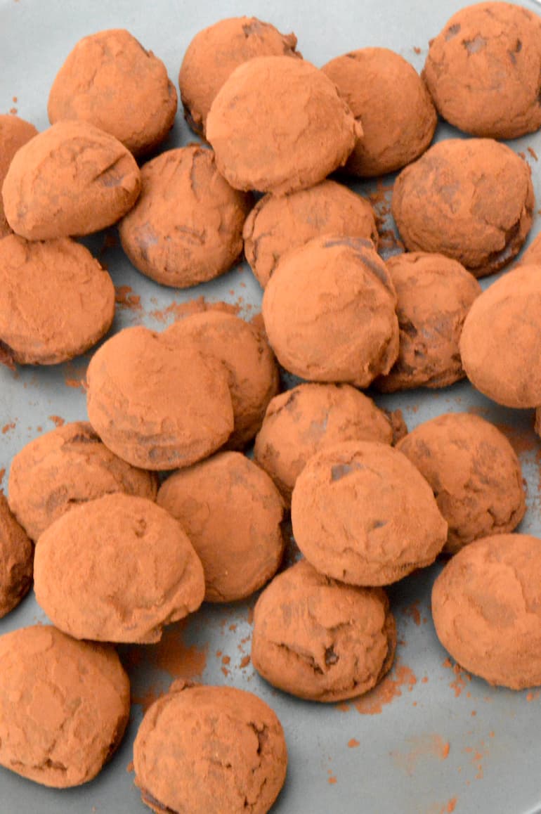 A pile of lemon balm chocolate truffles coated in cocoa powder.