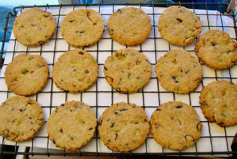 Pistachio and cacao nib shortbread biscuits cooling on a wire rack.