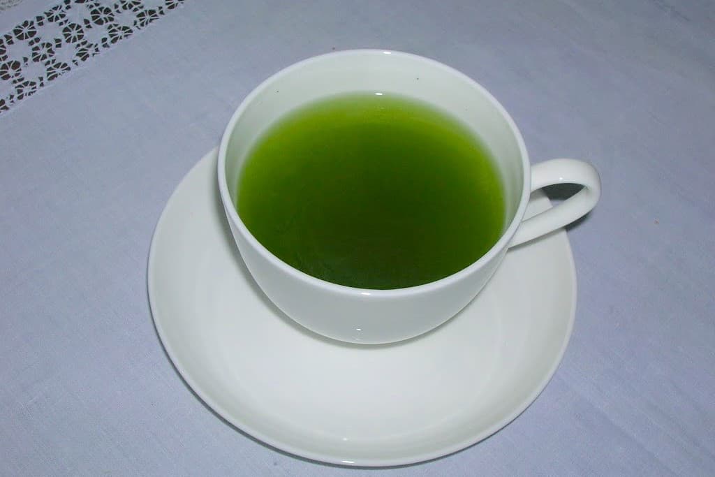Matcha green tea in a white cup and saucer.