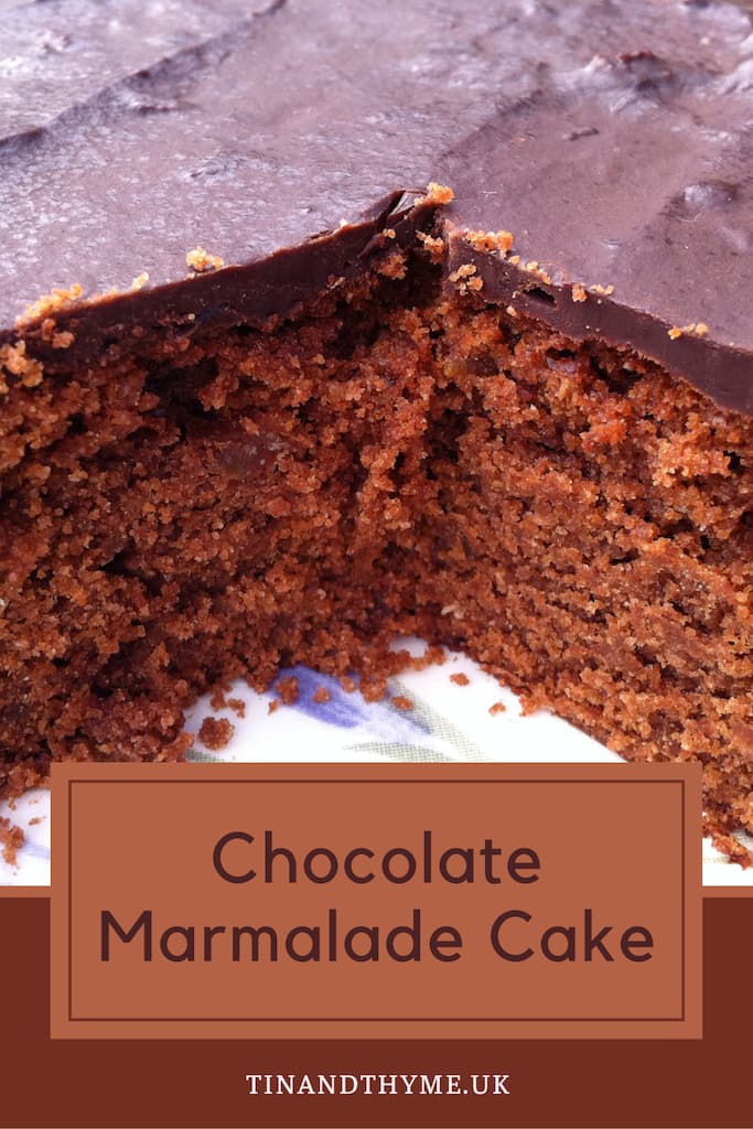 Close up of a chocolate marmalade cake with some slices already removed.