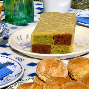 Chocolate matcha Battenberg cake on tea table with scones.