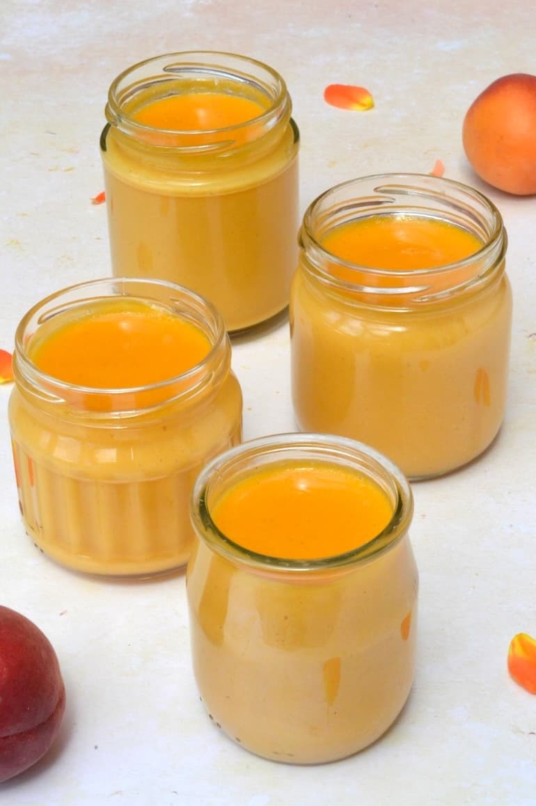 Four open jars of homemade apricot and cardamom curd.