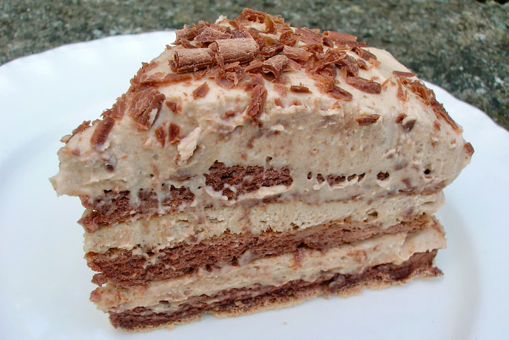 A slice of chestnut cream meringue cake on a white plate.