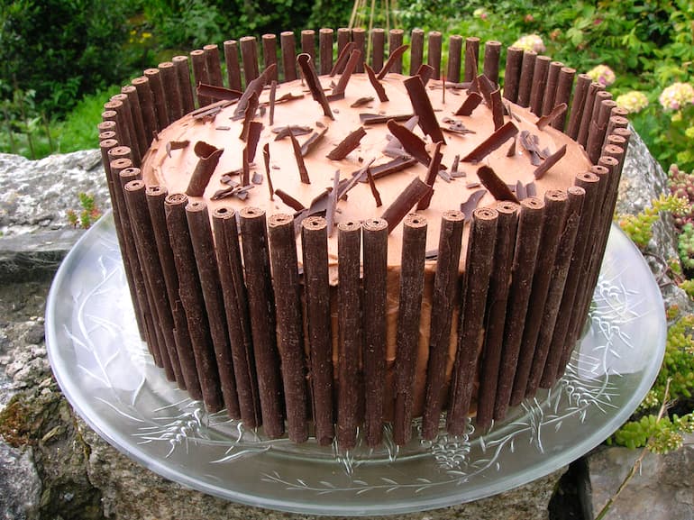 Triple layer matcha chocolate cake with chocolate batons.