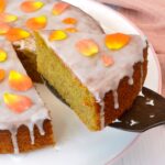 A slice of golden beetroot cake covered in light orange glaze.