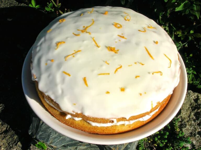 A layered orange cassata cake on a plate.