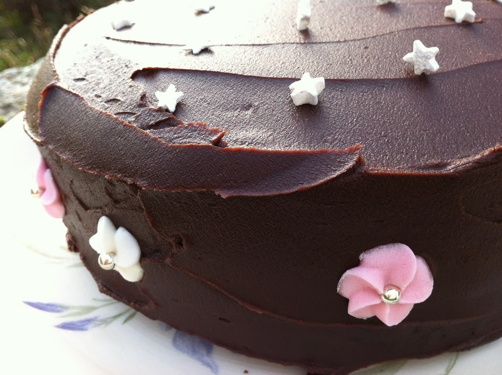 An iced chocolate fudge cake decorated with stars and flowers.