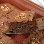 Black bean brownies in tin with one on cake slice.