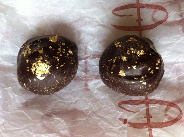 Two Champagne Truffles decorated with gold leaf.