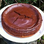 A whole baked chocolate cheesecake with a gluten-free marzipan base.