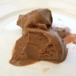 Homemade chilli chocolate ice cream melting on plate.