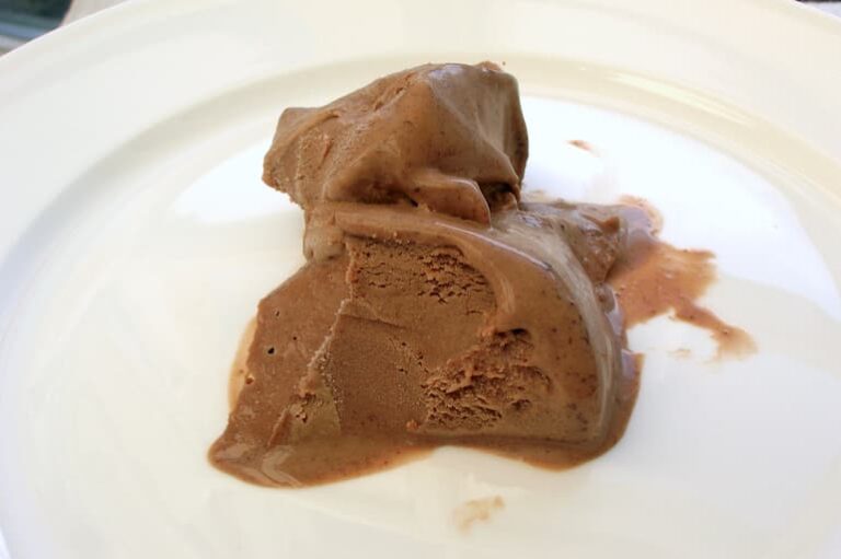 Homemade chilli chocolate ice cream melting on plate.