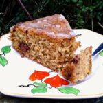 Slice of parsnip and walnut cake on tea plate with fork.