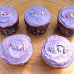 Five wild blueberry cupcakes on bamboo tray.