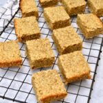 Homemade banana coconut flapjacks cooling on a wire rack.
