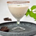 Cool and creamy chocolate mint cocktail in glass with sugar and cocoa dusted rim.