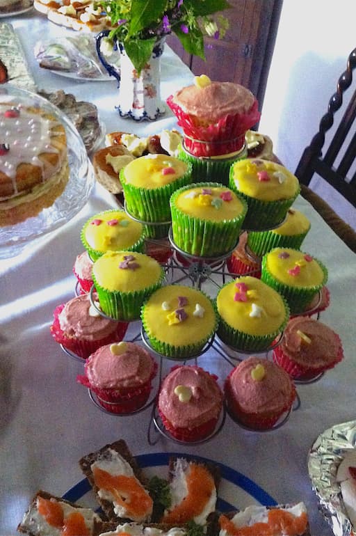 A tiered stand of raspberry and rose curd cupcakes and lemon curd cupcakes.