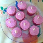 Glass plate holding homemade raspberry curd cupcakes.