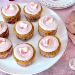 Stand of homemade raspberry curd cupcakes with one on plate with forks.
