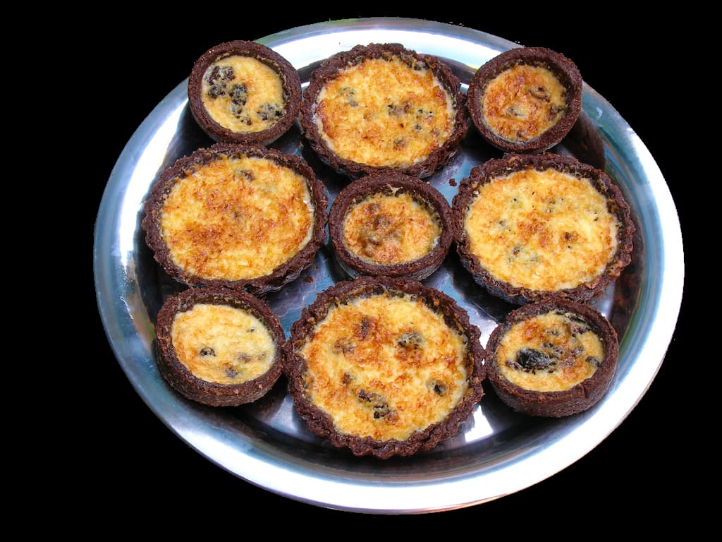 Yorkshire curd tarts with chocolate pastry on silver tray.