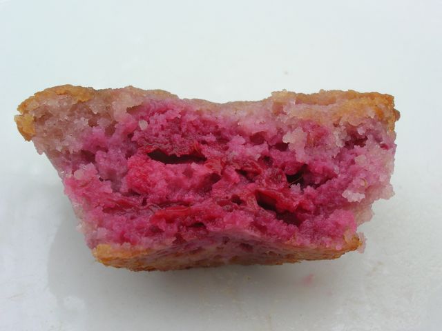 Half a bright pink raspberry friand.