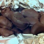 Homemade chocolate brazils nestled in silver paper.