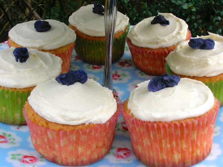 Plate of rose and violet fairy cakes.
