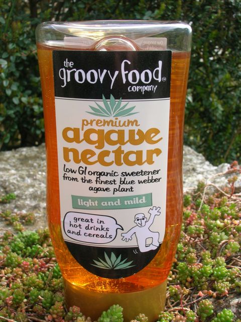 A bottle of agave nectar sitting on an outside wall.