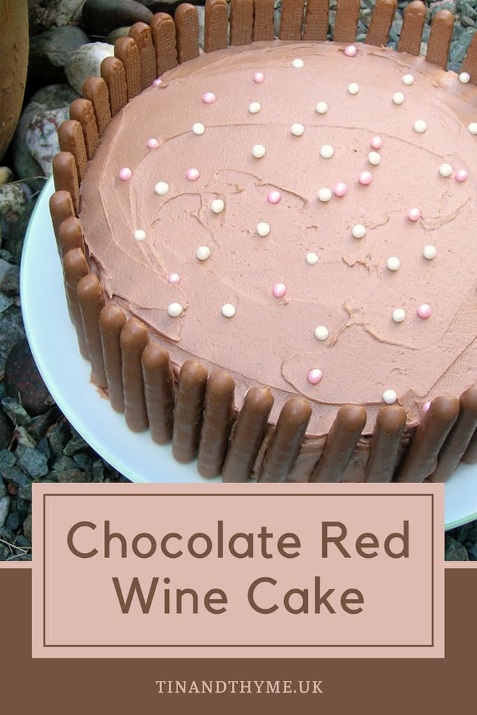 A chocolate red wine cake, iced with chocolate red wine buttercream and bordered with chocolate fingers.