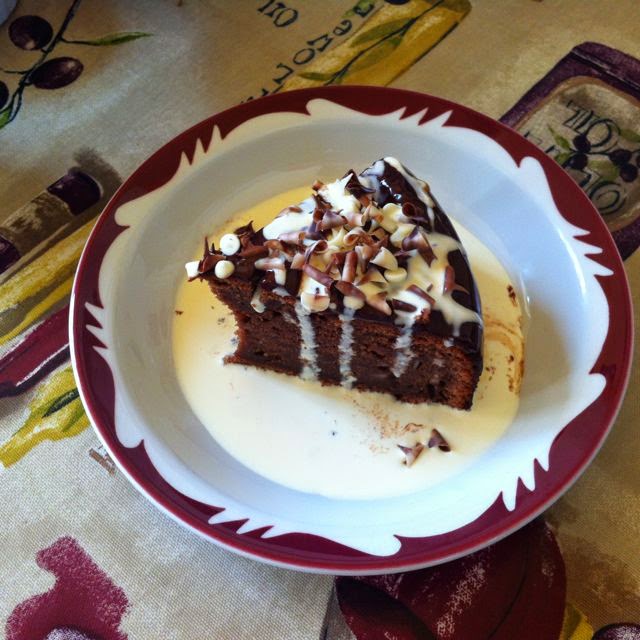 A slice of chocolate potato cake in a bowl with cream from The Hub Cafe.
