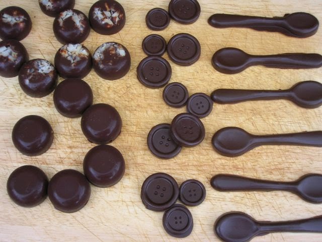 Raw chocolate formed into spoons, buttons and rounds.