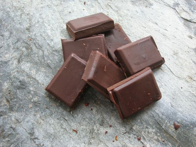 Squares of dark lavender flavoured chocolate on slate.