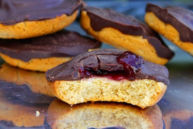 A pile of homemade jaffa cakes filled with mixed berry jam.