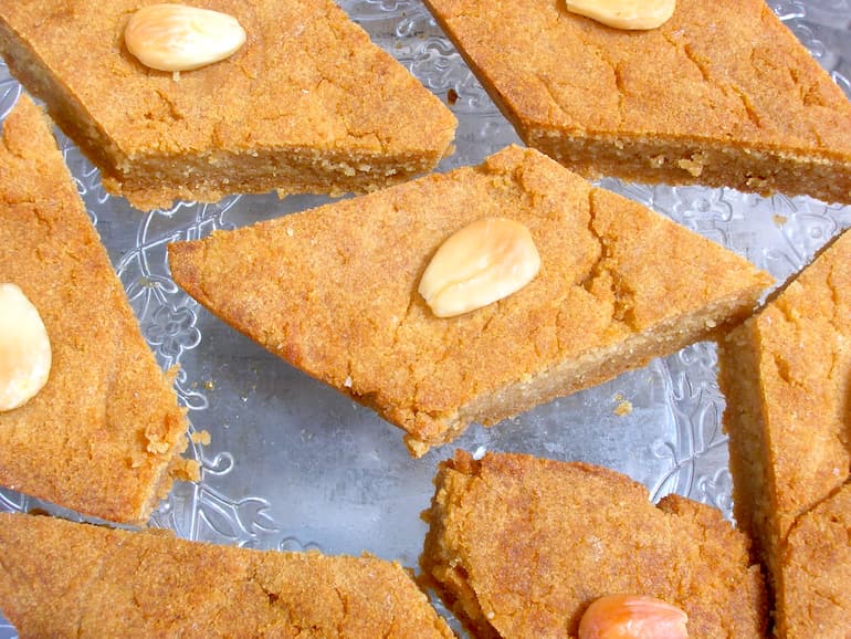 Diamond shaped basbousa slices with almond on top.