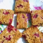 Plate of raspberry and white chocolate flapjacks.