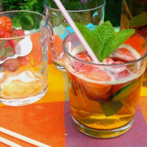 A glass of Pimms No 1, with strawberries, cucumber, ice and mint.
