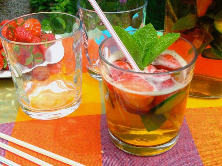 A glass of Pimms No 1, with strawberries, cucumber, ice and mint.