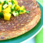 Courgette chickpea pancake with mango and cucumber salsa on top.