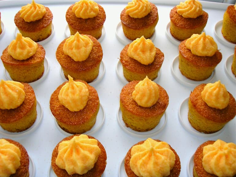 Homemade orange cakes on mini cupcake tray.