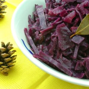 A half dish of Braised Red Cabbage with a couple of pine cones on the side.