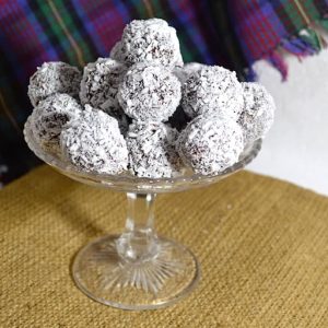 Coconut bliss balls piled on a cake stand.