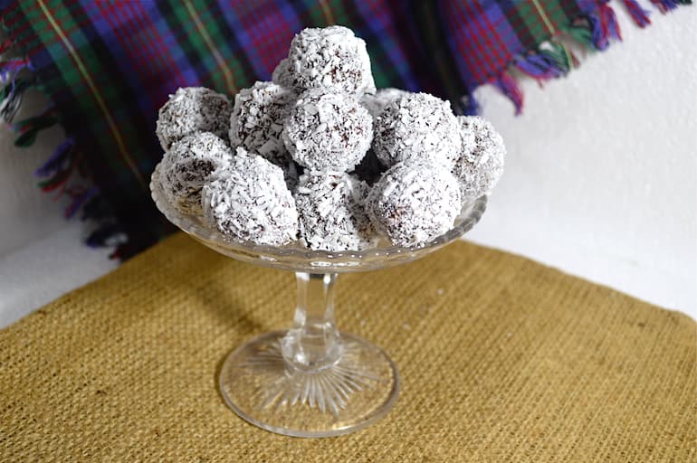 Coconut bliss balls piled on a cake stand.