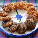 Ring of both black and white homemade sesame halva biscuits on plate.