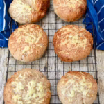 Wholemeal cheese baps cooling on wire rack.