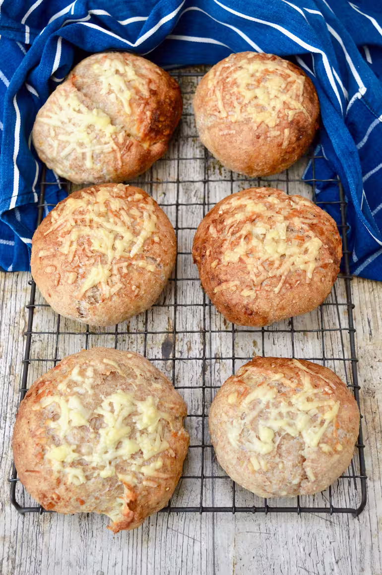 Wholemeal cheese baps cooling on wire rack.